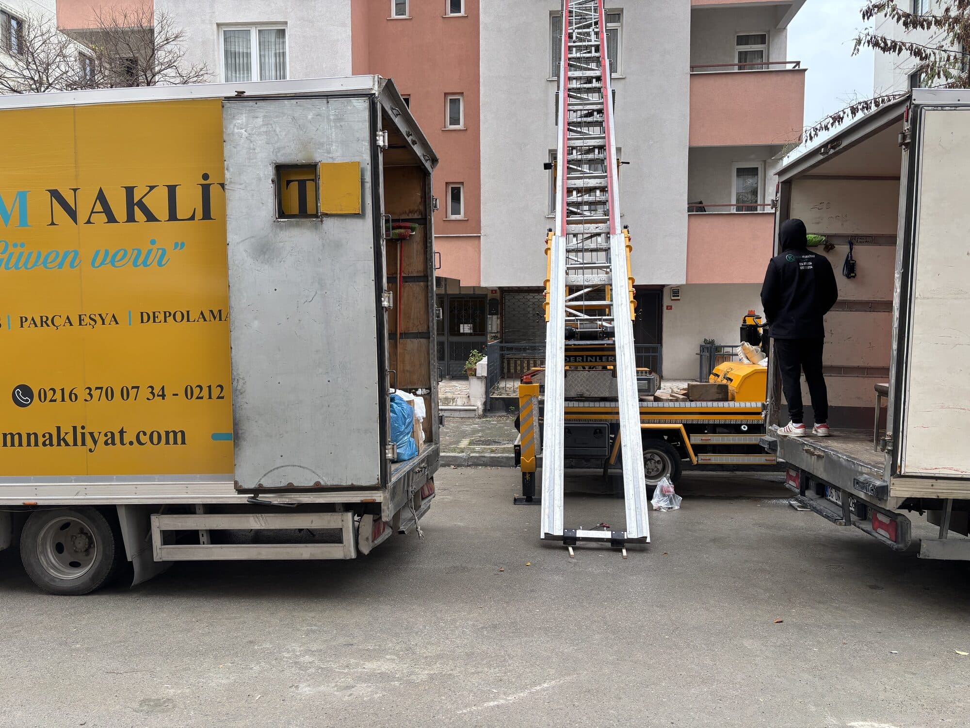Asansörlü nakliyat yükleme alanı — kamyonlar ve merdivenli asansör