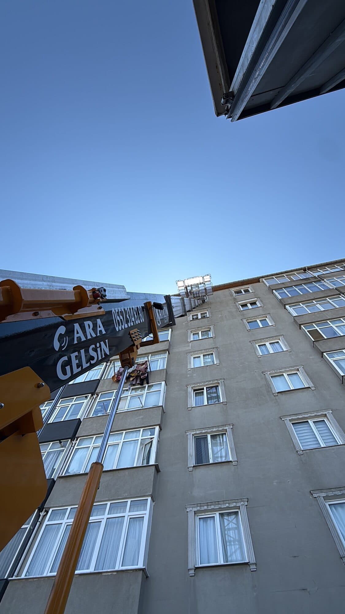 Eşya asansörü apartmanın üst katlarına uzanırken alttan görünüm