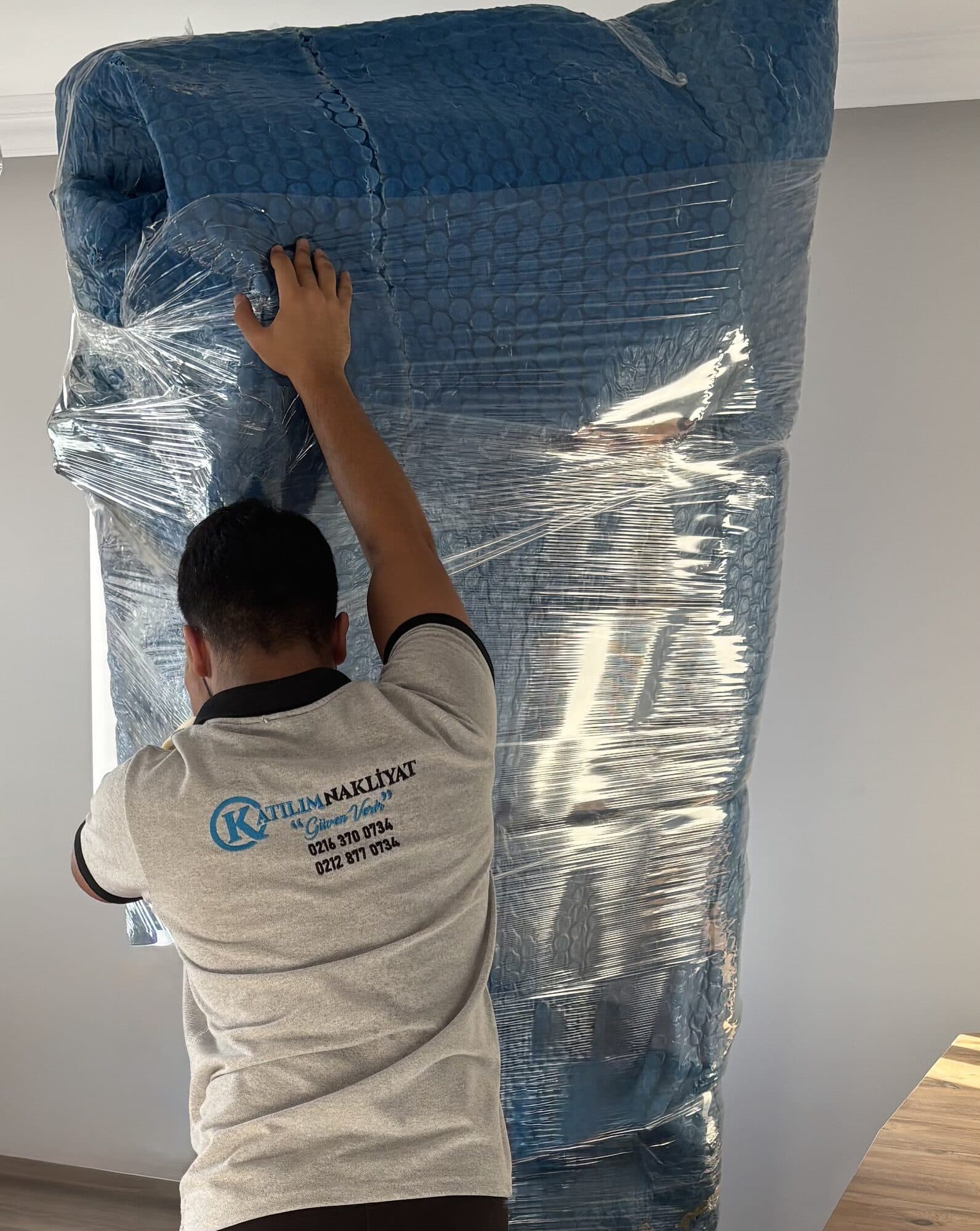 Personelin balonlu naylonla dolap paketleme çalışması